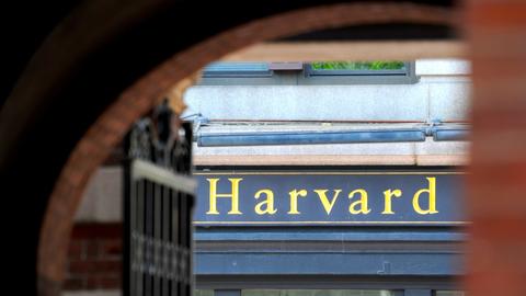 Η λέξη «Harvard» αποκαλύπτεται με χρυσά γράμματα, μέσα από μια αψιδωτή πύλη.