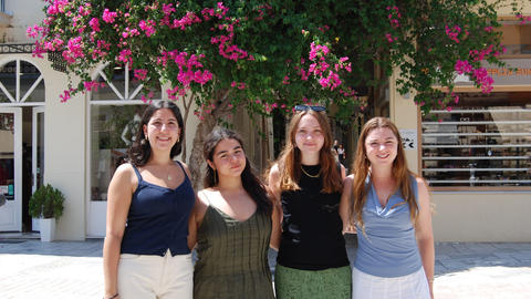 Τέσσερα νεαρά άτομα ποζάρουν κάτω από μια ανθισμένη βουκαμβίλια στο Ναύπλιο.