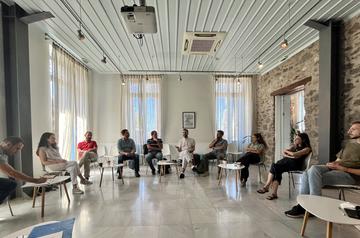 Οι συμμετέχοντες και οι συμμετέχουσες σε κύκλο στην αίθουσα διαλέξεων του ΚΕΣ, κατά τη συζήτηση μετά από συνεδρία.