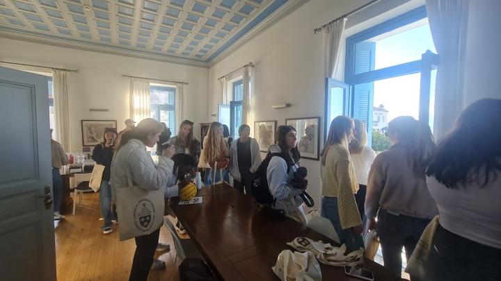 Νέες γυναίκες συναναστρέφονται σε ένα χαλαρό περιβάλλον ενός ηλιόλουστου δωματίου με μεγάλα παράθυρα.