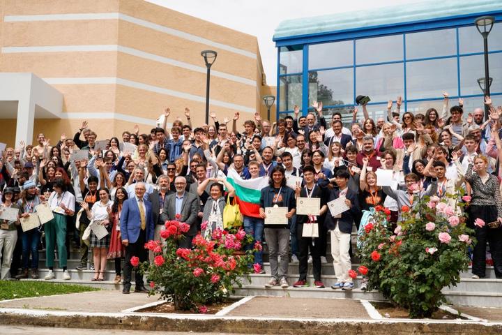 Ομαδική φωτογραφία όλων των συμμετεχόντων μαθητών, καθηγητών, εθελοντών και προσωπικού που χαμογελούν και ποζάρουν σε εξωτερικό χώρο.